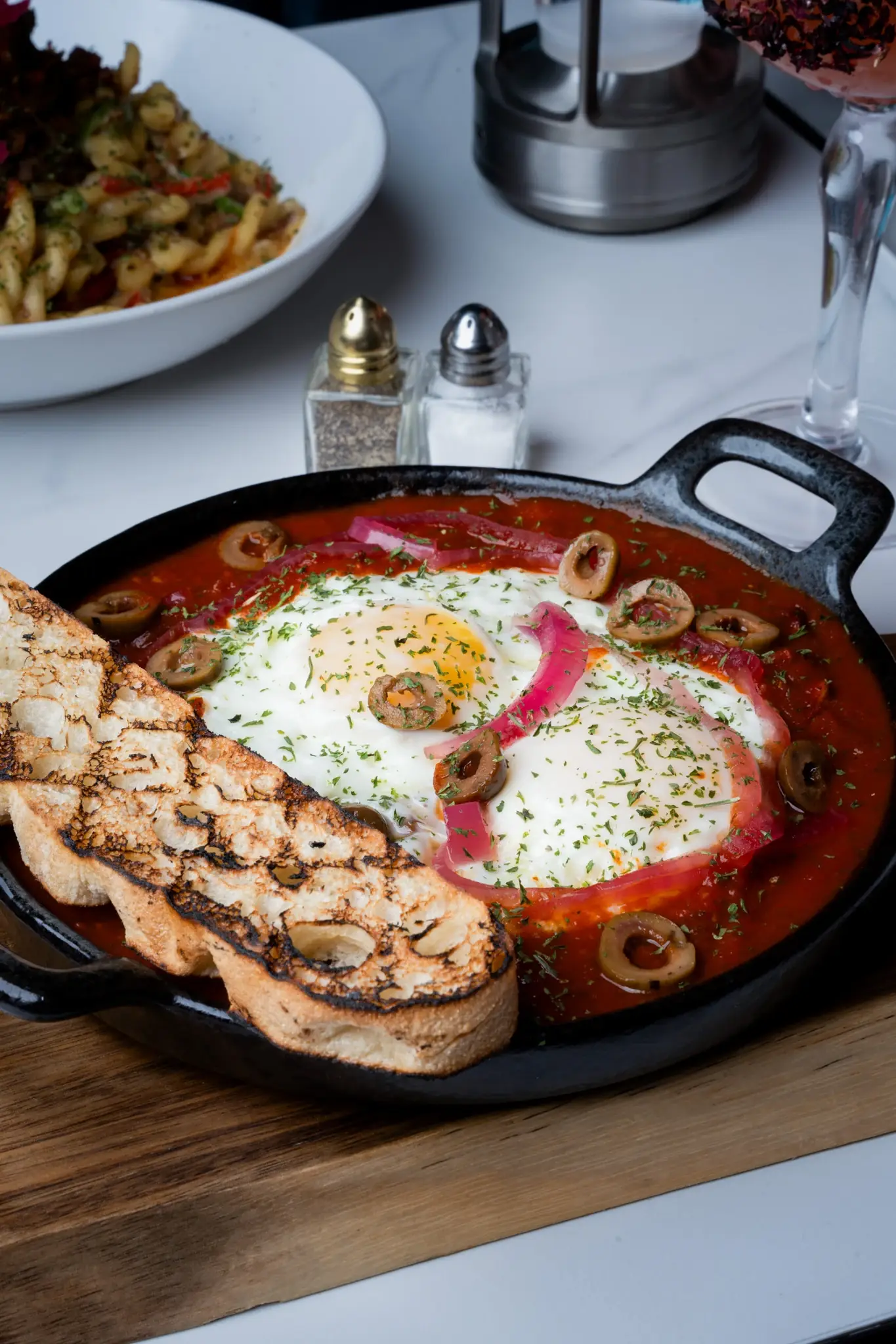 Baked eggs in heirloom tomato sauce with focaccia, a brunch dish in Alpharetta