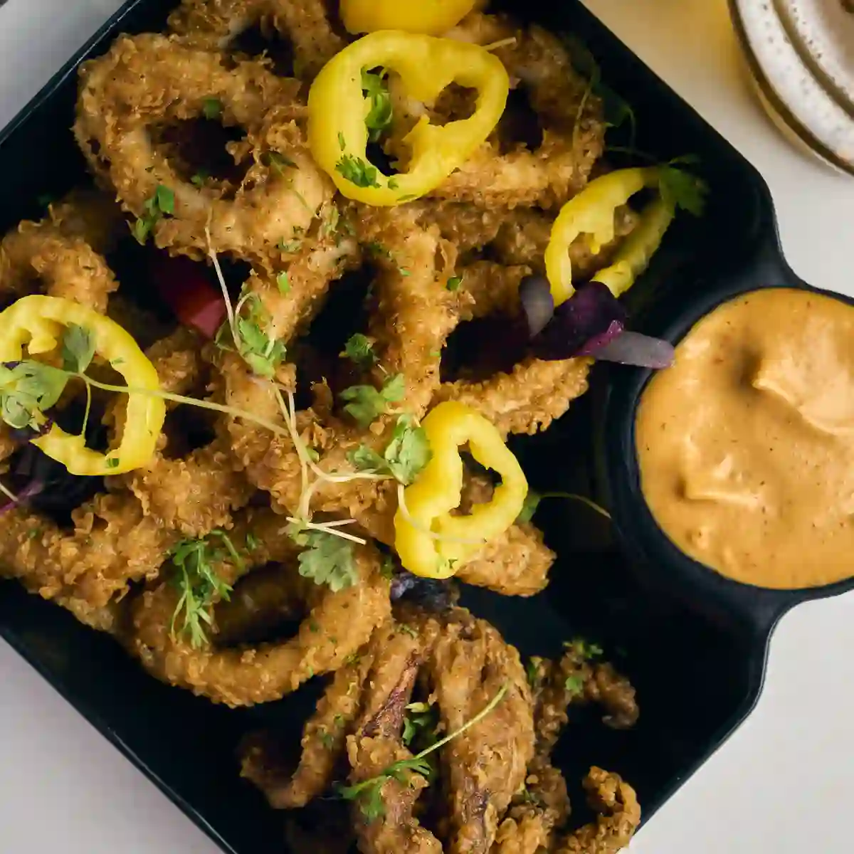 Fried calamari with pickled peppers and dipping sauce, served at happy hour in Alpharetta