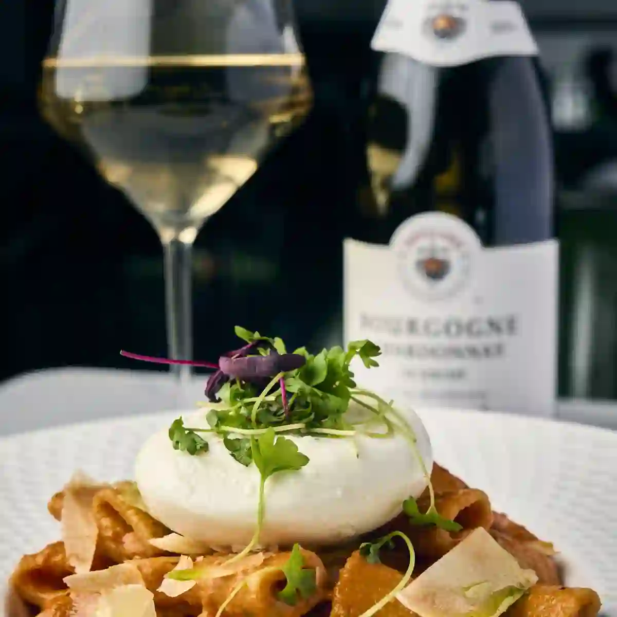 Rigatoni alla vodka with a glass of white wine and a bottle of Bourgogne chardonnay